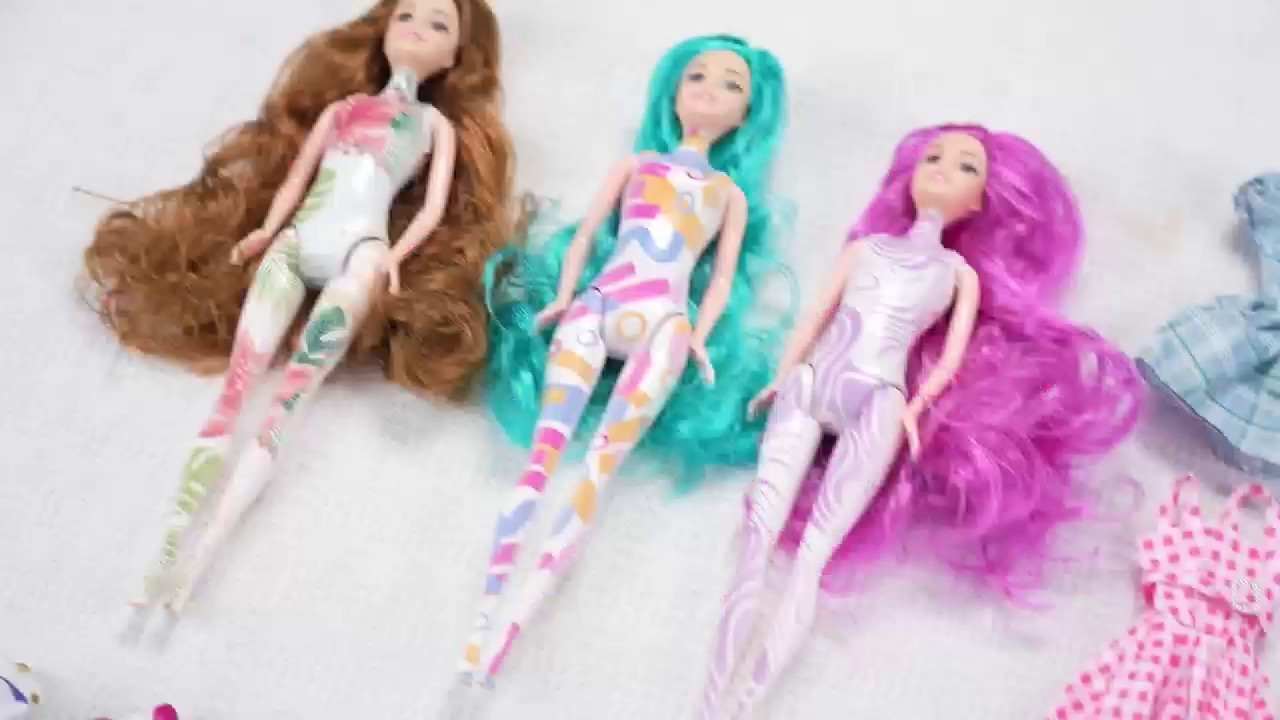 Three water-reveal surprise dolls with color-change body patterns and colorful hair, before water reveal